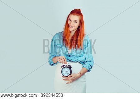 Happy Woman Smiling Holding A Clock At Big Pregnant Belly Showing That Her Biological Watch Is Ticki