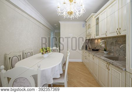 Luxury modern neoclassic beige kitchen interior with locker and dining table