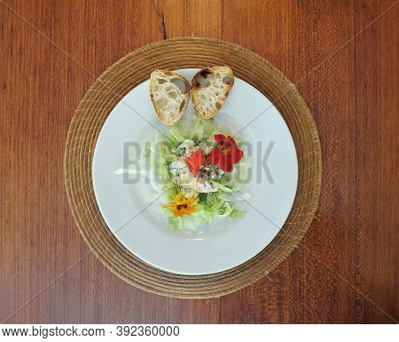 Top View Of Green Salad With Comestible Flowers And Bread.