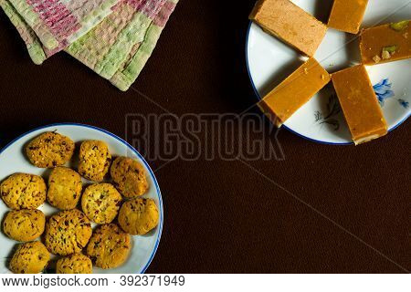 Barfi And Cookies In A White Plate On A Brown Background