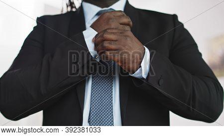 Stylish African Man In A Suit Adjusting Sleaves. High Quality Photo