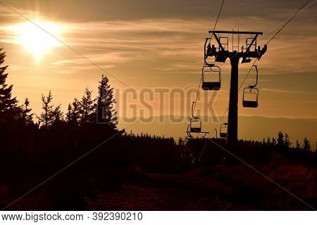 Ski Chair Lift In The Mountains At Orange Sunrise