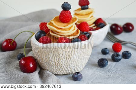 Pancake Cereal, Mini Pancakes In A Bowl With Blueberries, Raspberries, Cherries. Healthy Nutrition. 
