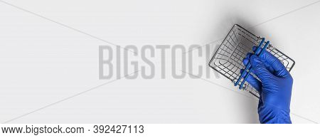 Shopping Metal Empty Basket In Male Hand In Blue Protecive Glove. Shopping During Coronavirus Lockdo
