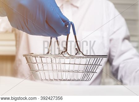 Shopping Metal Empty Basket In Male Hand In Blue Protecive Glove. Shopping During Coronavirus Lockdo