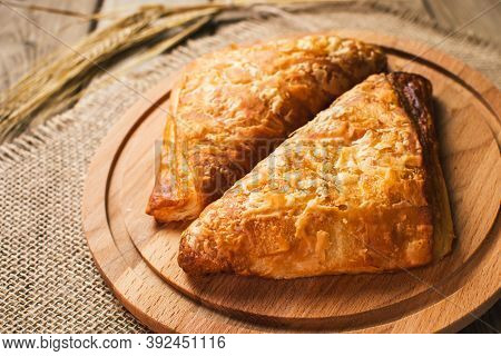 Burekas Filled With Cheese On A Wooden Table And Cutting Board.