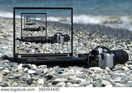 The Droste Effect Concept: Laptop And Camera On The Beach With Picture Recursively Appearing Within 