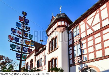 Lorsch, Germany - October 2020: Traditional Guild Pole And Part Of Old Historic City Hall Building I