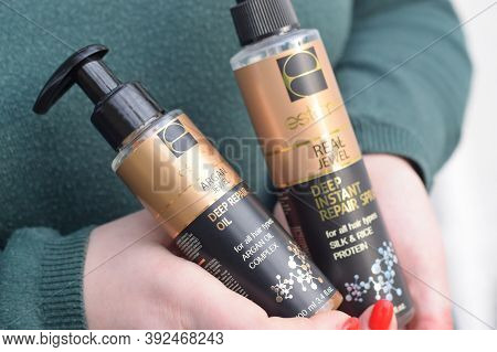 Young Girl Holds Estima Products. Estima Argan Jewel Deep Repair Oil And Real Jewel Deep Instant Rep