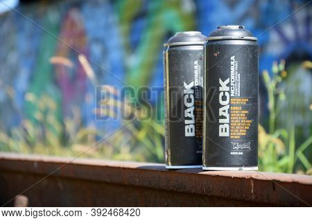 Used Montana Black Aerosol Spray Cans Against Graffiti Paintings. Mtn Or Montana-cans Is Manufacture