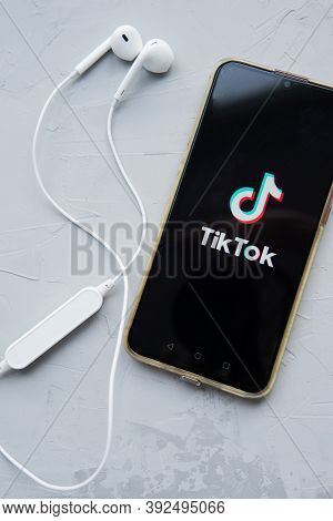 Tver, Russia-february 12, 2020 Tik Tok Logo On The Smartphone Screen And White Wireless Headphones O