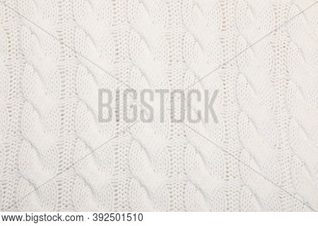 Real white knitted fabric with cable pattern textured background