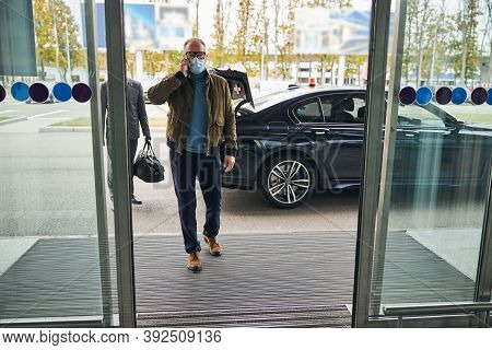 Man In A Face Mask Followed By His Private Driver