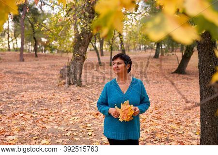 Beautiful Caucasian Woman Walking And Having Fun Outdoors In Autumn Time. Bright Yeallow Colors