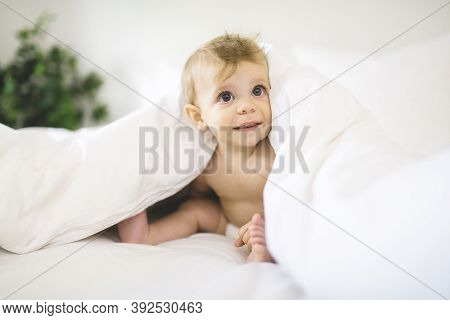 Cute Happy Baby Girl In Diaper On Bed