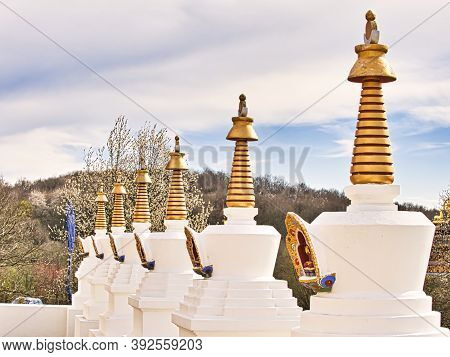 La Boulaye, France - April Circa, 2018. Several Small White Stupas With Traditional Eyes Of Buddha P