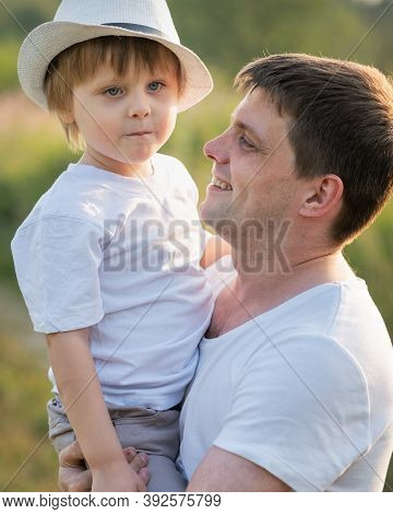 Portrait Of Fathe And Son At Meadow In Summer Day