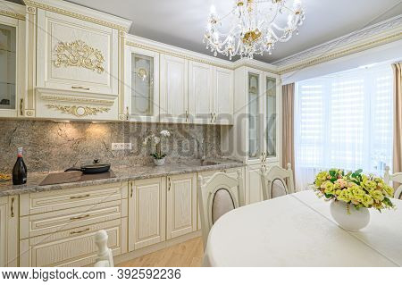 Luxury modern neoclassic beige kitchen interior, dining table and window