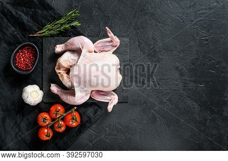 Raw Whole Poult With Rosemary And Pink Pepper. Black Background. Top View. Space For Text
