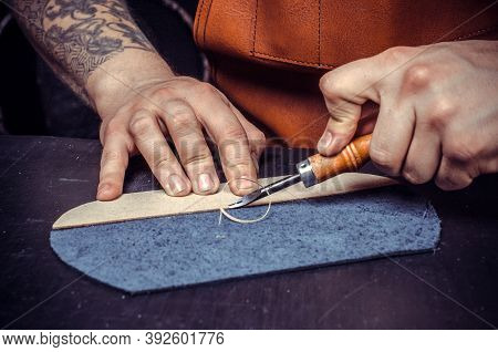 Professional Leather Worker Focused On His Work In A Workshop