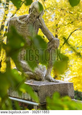 Skinny Sad Man Secure Tombstone. Granite Statue Sitting On A Tombstone. 24th Of October 2020. Hronov