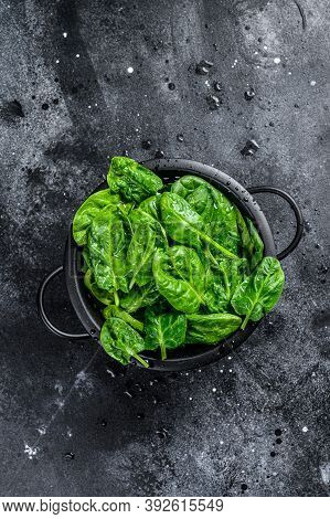 Fresh Spinach Leaves In A Colander. Black Background. Top View