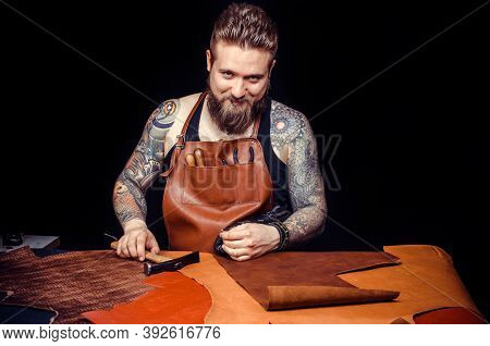 Leather Craftsman Producing A Leatherwork At His Desk