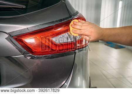 Worker Hand Polishes Headlight With Sponge And Wax Polish Paste, Restoration Of Headlights In Car De