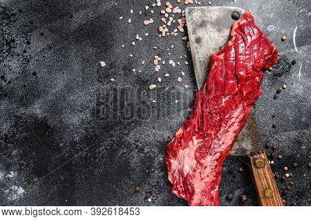 Raw Skirt, Machete Steak On A Meat Cleaver. Black Background. Top View. Copy Space
