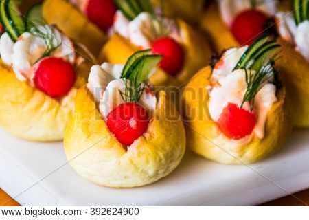 Many Mini Sandwiches With Shrimp, Watermelon And Cocumber Slices Served On A White Board