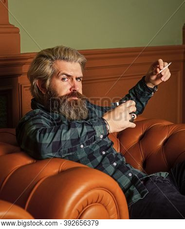 Smoke Cigarette While Drink Brandy Or Cognac. Hard Beverage For Real Men. Brutal Man Drinking Whiske
