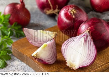 Purple Onions Close-up. Fresh Whole Purple Onions And One Sliced Onion On A Stone Countertop.
