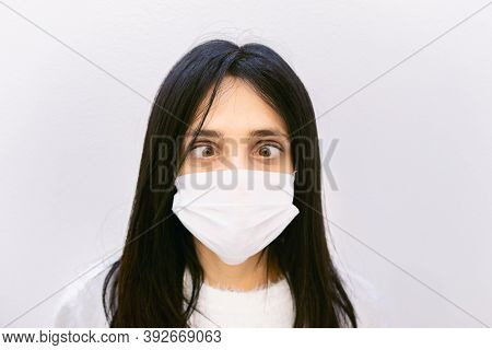 Youn Caucasian Woman Shows Crazy Eye Look Down To Whte Face Mask. Concept Of Sickness And Human Sill