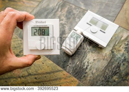 Paris, France - Oct 25, 2020: Pov Man Showing Vaillant Vr51 Room Thermostat With Other Iot Device De