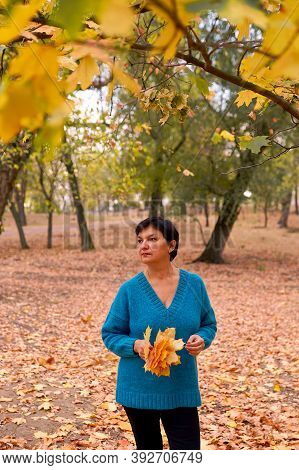 Beautiful Caucasian Woman Walking And Having Fun Outdoors In Autumn Time. Bright Yeallow Colors