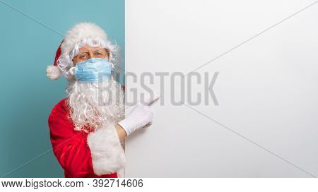 Merry Christmas and Happy Holidays! Santa Claus in face mask on bright color background. Covid-2019