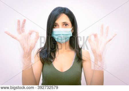 Close Up Of Woman With Face Mask Showsng Okey Sign With Hands And Looking Straight. Concept Of Follo