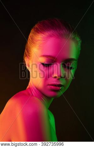 Mavelous. Portrait Of Female Fashion Model In Neon Light On Dark Studio Background. Beautiful Caucas