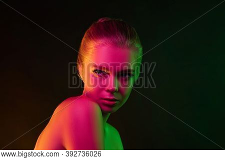 Mavelous. Portrait Of Female Fashion Model In Neon Light On Dark Studio Background. Beautiful Caucas