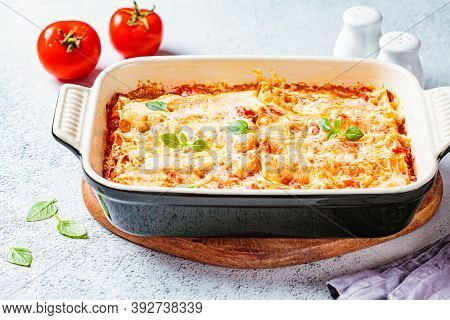 Traditional Cannelloni With Meat, Tomato Sauce And Cheese In A Baking Dish, Gray Background. Italian