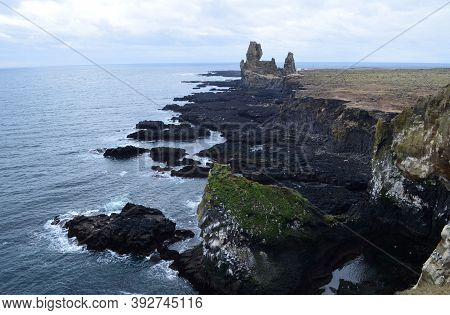 Rugged Lava Rock Cliffs Along The Coast Of Iceland.