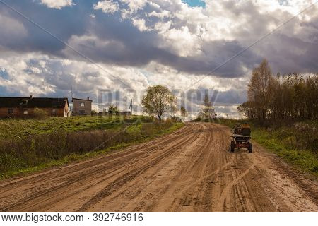 An Empty Country Road In Belarus In A Cloudy Sunny Day With A Man In Horse Cart.