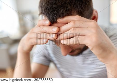 stress, failure and people concept - close up of stressed young man having headache at home