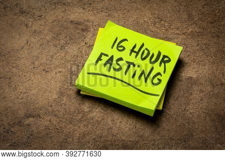 16 hour fasting reminder note on a brown textured bark paper, healthy lifestyle, intermittent fasting, diet and weight loss, time-restricted eating, daily eating window concept