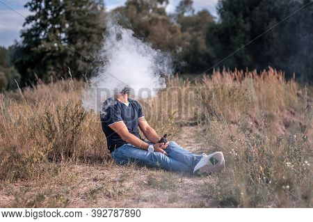 Handsome Vape Man Blows Up A Couple An E-cigarette. Electronic Cigarette As Alternative To Tobacco.
