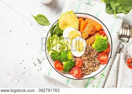 Buddha Bowl. Vegan Dish With Buckwheat, Egg, Avocado And Fresh Vegetables. Top View At Kwhite Itchen