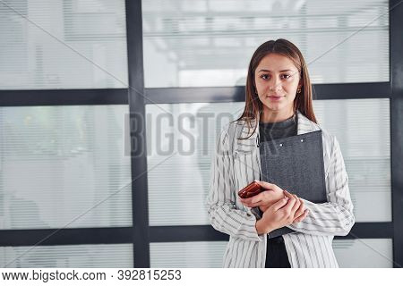 Portrait Of Young Woman In White Formal Clothes That Standing Indoors.