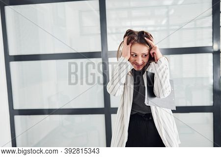 Portrait Of Young Woman In White Formal Clothes That Standing Indoors.