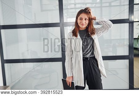 Portrait Of Young Woman In White Formal Clothes That Standing Indoors.