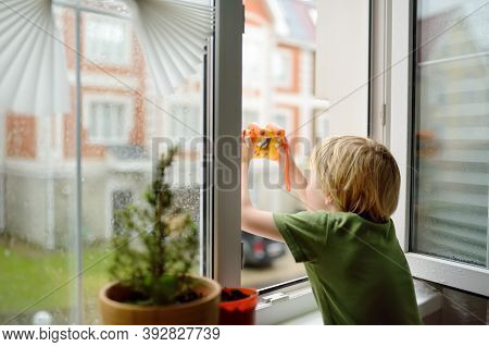 Little Boy Watching The Rain Outside At Opened Window And Taking Photo. Bad Weather - Wind And Downp